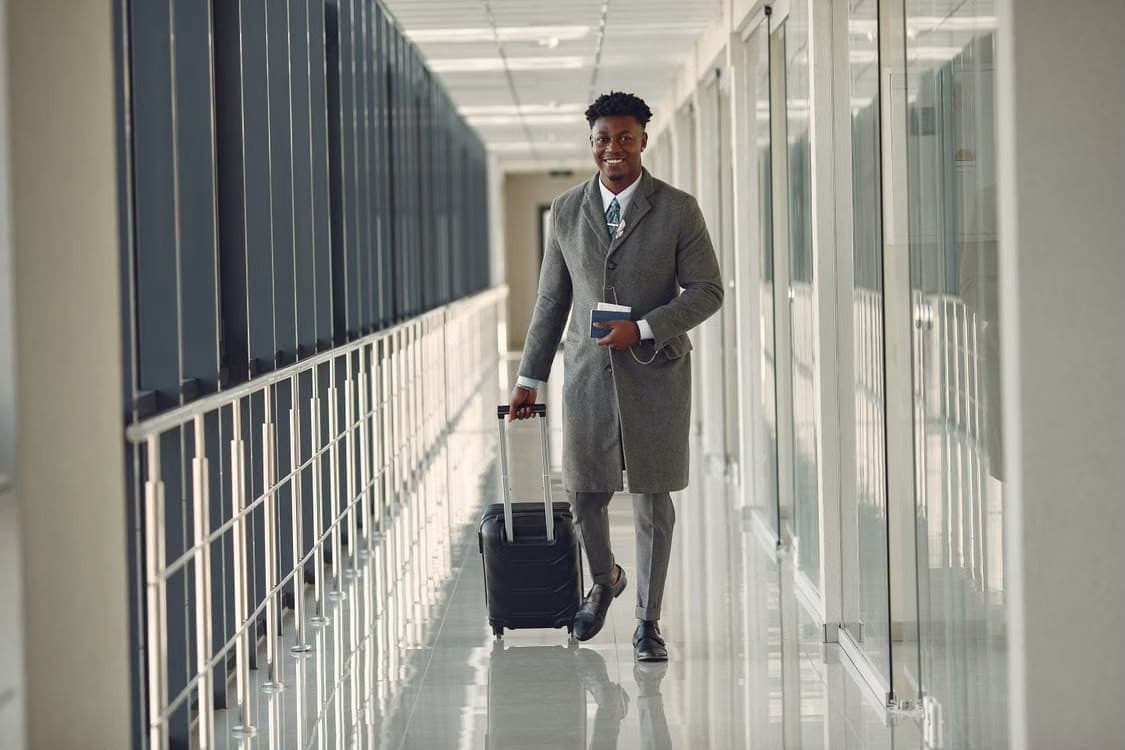 Business traveller with a suitcase walking along an airport walkway