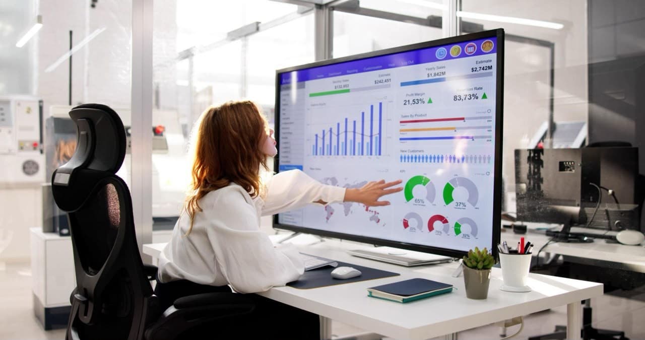 Analyst reviewing a reporting dashboard on a large screen